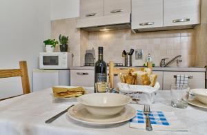 una cocina con una mesa con comida y una botella de vino en Colorato e vivace bilocale, en Lucca