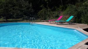 a swimming pool with two chairs and a table at gite ventoux in Loriol-du-Comtat