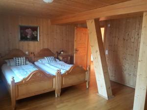 - 2 lits dans une chambre dotée de murs en bois dans l'établissement Ferienhaus Schweissing, à Fröhnd
