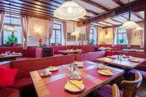 a restaurant with wooden tables and red booths at Hotel-Restaurant Zur Kanne in Schifferstadt