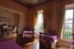 a dining room with purple tables and chairs and windows at Posada Casa de Valle in Colindres +70 photos
