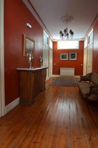 una sala de estar con paredes rojas y suelo de madera. en Posada Casa de Valle, en Colindres