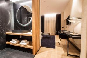 a bathroom with a sink and a desk with a mirror at Zenit Convento San Martin in Donostia-San Sebastián