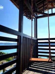 a swing on a porch with the ocean in the background at hanon～波音～ in Tatsugo