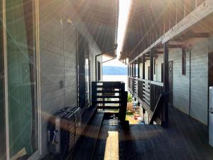 an empty train hallway with luggage on the train at hanon～波音～ in Tatsugo