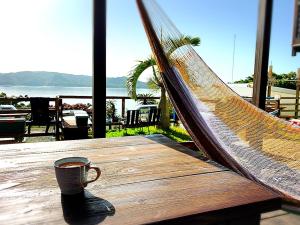 a cup of coffee sitting in a hammock on a table at hanon～波音～ in Tatsugo
