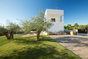 a white house with trees in the yard at Parabellum in L'Ampolla