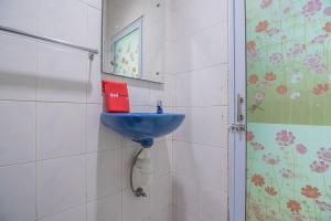 a bathroom with a blue sink and a red book at RedDoorz near Nagoya Citywalk Batam 2 in Nagoya +21 photos