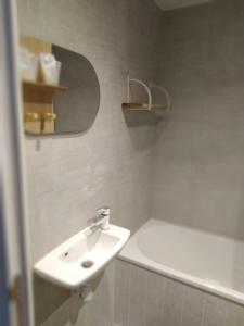 a bathroom with a sink and a bath tub at Le Risle - Hôtel in Montfort-sur-Risle +20 photos