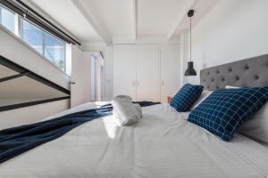 a bedroom with a large bed with blue pillows at StayCentral - Fitzroy Converted Warehouse Penthouse in Melbourne