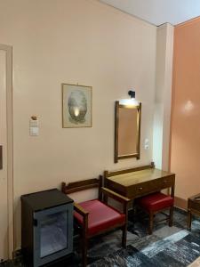 a room with a tv and a table and a mirror at Hotel Cosmos in Athens