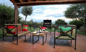 een patio met 2 stoelen, een tafel en een televisie bij Francolin Cottage at Great Rift Valley Lodge & Golf Resort Naivasha in Naivasha