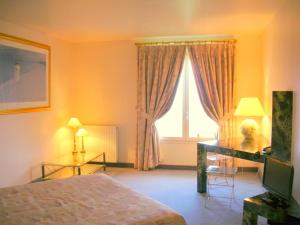 a bedroom with a bed and a television and a window at Crispol in Saint-Père