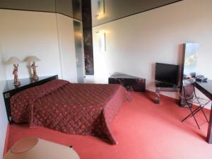 a bedroom with a red bed and a television at Crispol in Saint-Père