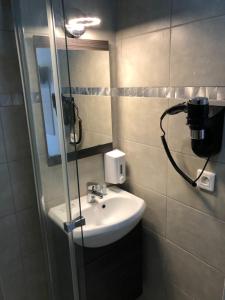 a bathroom with a sink, toilet and mirror at Hôtel de Ménilmontant in Paris