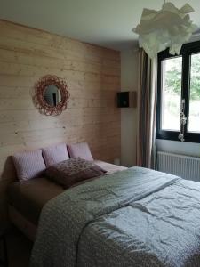 a bedroom with a bed and a mirror on the wall at Chalet Dionysos in Murat-le-Quaire