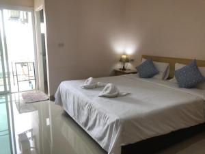 a bedroom with a white bed with towels on it at Connect Apartment in Nakhon Ratchasima