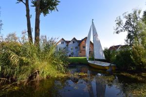 a sailboat on the water in front of a house at KapLuv Plau am See in Plau am See