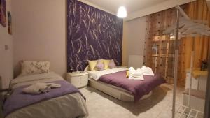 a bedroom with two beds with purple sheets at Panorama Center apartment in Xanthi