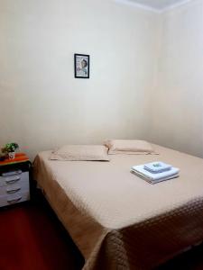 uma cama num quarto com uma fotografia na parede em Pousada Sayonara em Atibaia