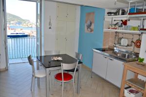 een keuken met een tafel en stoelen en uitzicht op de oceaan bij Maridea - La Darsena in Ponza