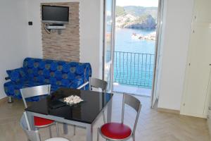 een woonkamer met een tafel en een blauwe bank bij Maridea - La Darsena in Ponza