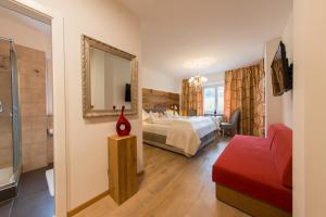 Habitación de hotel con cama y espejo en Hotel Pension Verdorfer en Merano