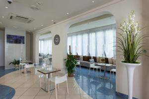 salon z kanapą, stołami i krzesłami w obiekcie Hotel Aurora Mare w Rimini
