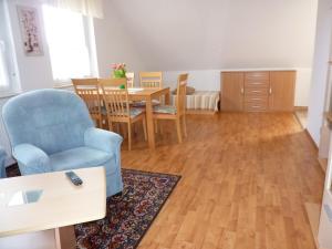 a living room with a blue chair and a table at Ferienwohnung Lehmann, Ursel in Burg Kauper