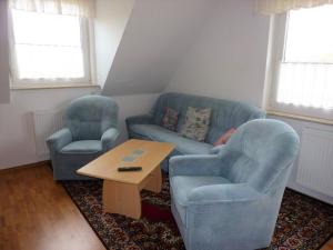 sala de estar con 2 sillas azules y mesa en Ferienwohnung Lehmann, Ursel, en Burg Kauper