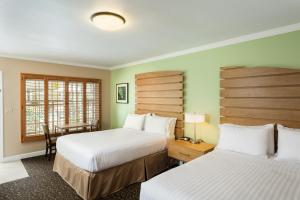 a hotel room with two beds and two lamps at Holiday Inn Express and Suites La Jolla - Windansea Beach, and IHG Hotel in San Diego