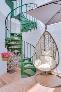 uma cadeira de baloiço em frente a uma escada em espiral em Groundfloor em Faro