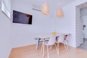 a white dining room with a table and chairs at Groundfloor in Faro