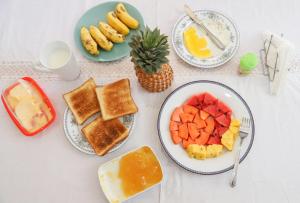 a table topped with plates of fruit and toast at HOSTEL KATUNAYAKE At COLOMBO AIRPORT TRANSIT in Katunayake
