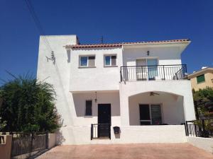 a white house with a balcony on top of it at Villa Laurel in Peyia