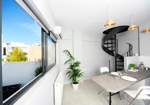 a dining room with a table and a large window at Live in Athens, PSYRRI Central Apartments in Athens