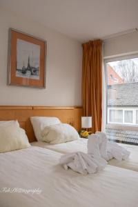 a bedroom with a bed with white sheets and a window at Hotel 2000 Valkenburg in Valkenburg