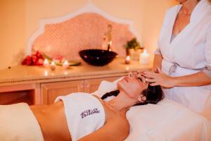 a woman laying in a bed getting her hair done at Hotel Terme Tritone Resort & Spa in Ischia