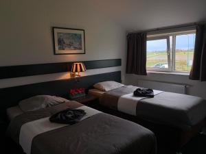 a hotel room with two beds and a window at Hotel Dijkzicht in Oudeschip