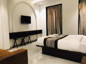 um quarto com uma cama com um piano e uma cama sidx sidx sidx em Hotel Flora Suites - Fort em Mumbai