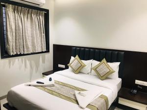 a bedroom with a large bed with white sheets and pillows at Hotel Flora Suites - Fort in Mumbai