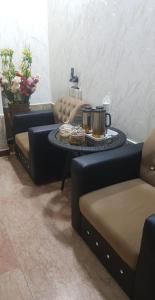 Concord Beach House في دبا: غرفة معيشة مع طاولة قهوة وكرسيين