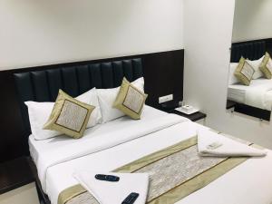 a bedroom with a large bed with a mirror at Hotel Flora Suites - Fort in Mumbai