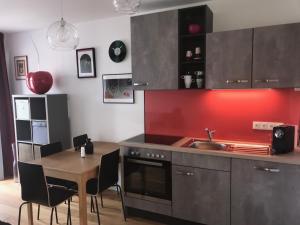 una cucina con un lavello e un tavolo con sedie di Red Flower Apartment with Pool - 5 min to Lake a Vienna