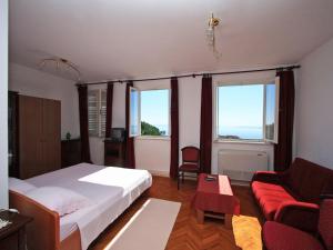ein Schlafzimmer mit einem Bett und einer Couch und Fenstern in der Unterkunft Rooms Vjera in Dubrovnik