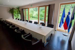 - une longue table dans une pièce avec des chaises et des drapeaux dans l'établissement Penzion Repnik, à Kamnik