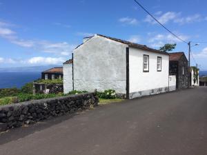 a white house on the side of a road at CASA DO CASTANHEIRO in Santo Antonio