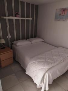 - une chambre avec un lit blanc et une table de nuit dans l'établissement Apartamento duplex en centro de Sevilla, à Séville