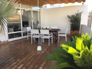 eine Terrasse mit einem Tisch, Stühlen und Pflanzen in der Unterkunft La terraza de San Pedro in Cádiz