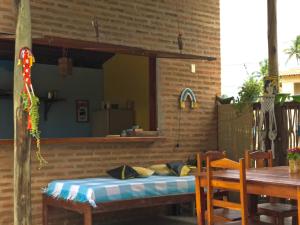 a patio with a table and a bed on a brick wall at Pousada kaz'oca in Icaraí +51 photos